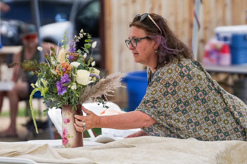 A florist arranging a tall seasonal bouquet on site before an event