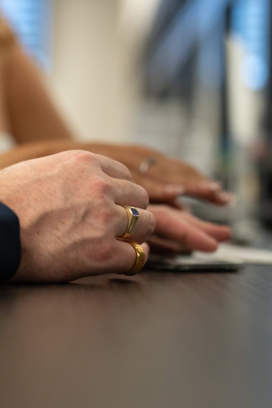 Close detail of a pair of hands resting flat on a worktable
