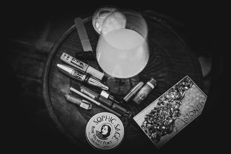A dark tray styled with a drink, packaged goods and branded product cards