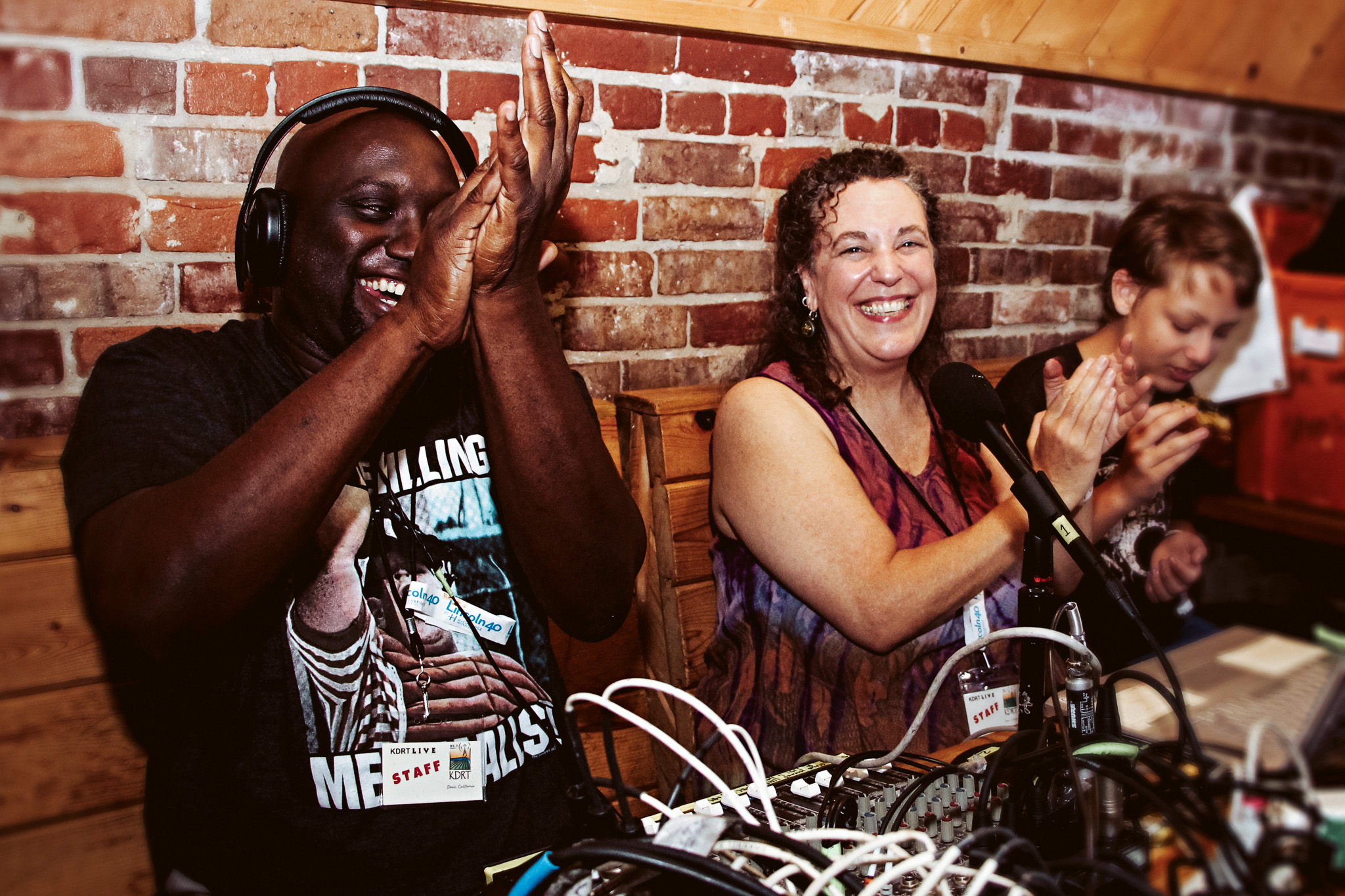 Two people laughing together during a podcast or broadcast studio session
