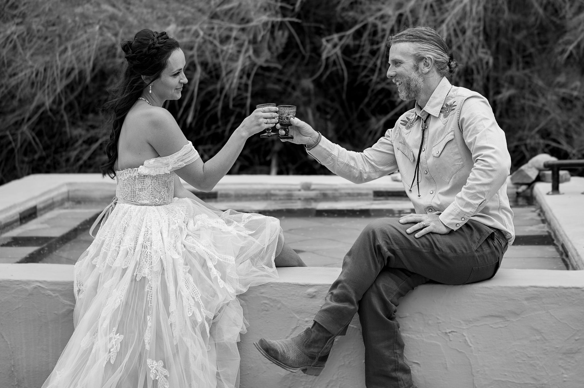 Bride and groom toasting with ornate goblets at their outdoor Colorado elopement celebration in black and white