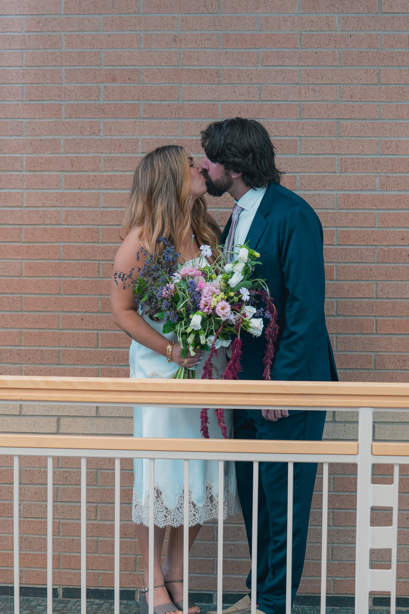 Non-hiking Colorado elopement photographer — couple kissing near a courthouse bridge