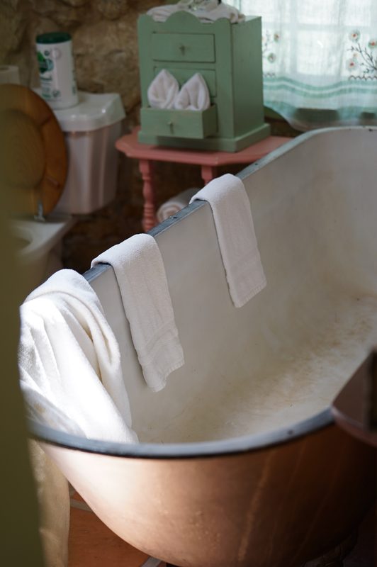 White towels draped over a vintage clawfoot bathtub at a hot spring wedding venue