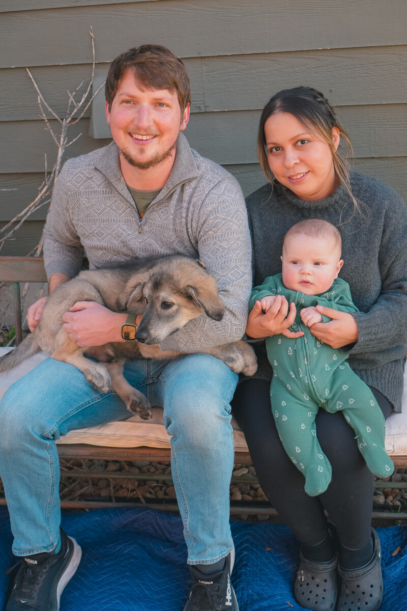 A couple holding their baby and their puppy during a candid fall mini session in Sacramento