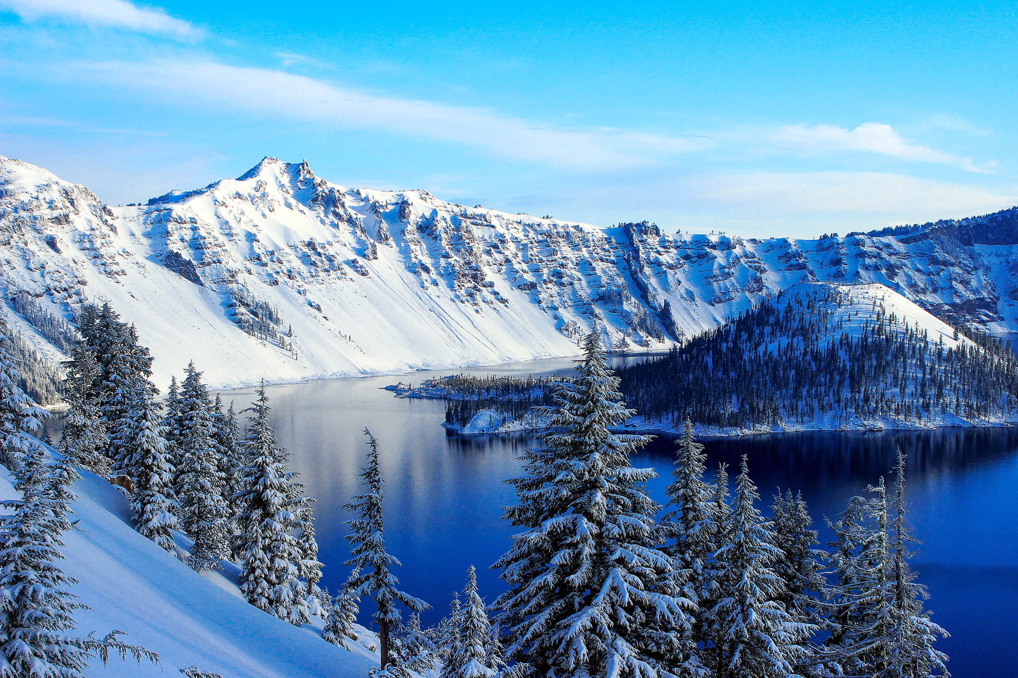 Crater Lake's deep blue water and snow-dusted volcanic crater walls photographed during destination retreat travel
