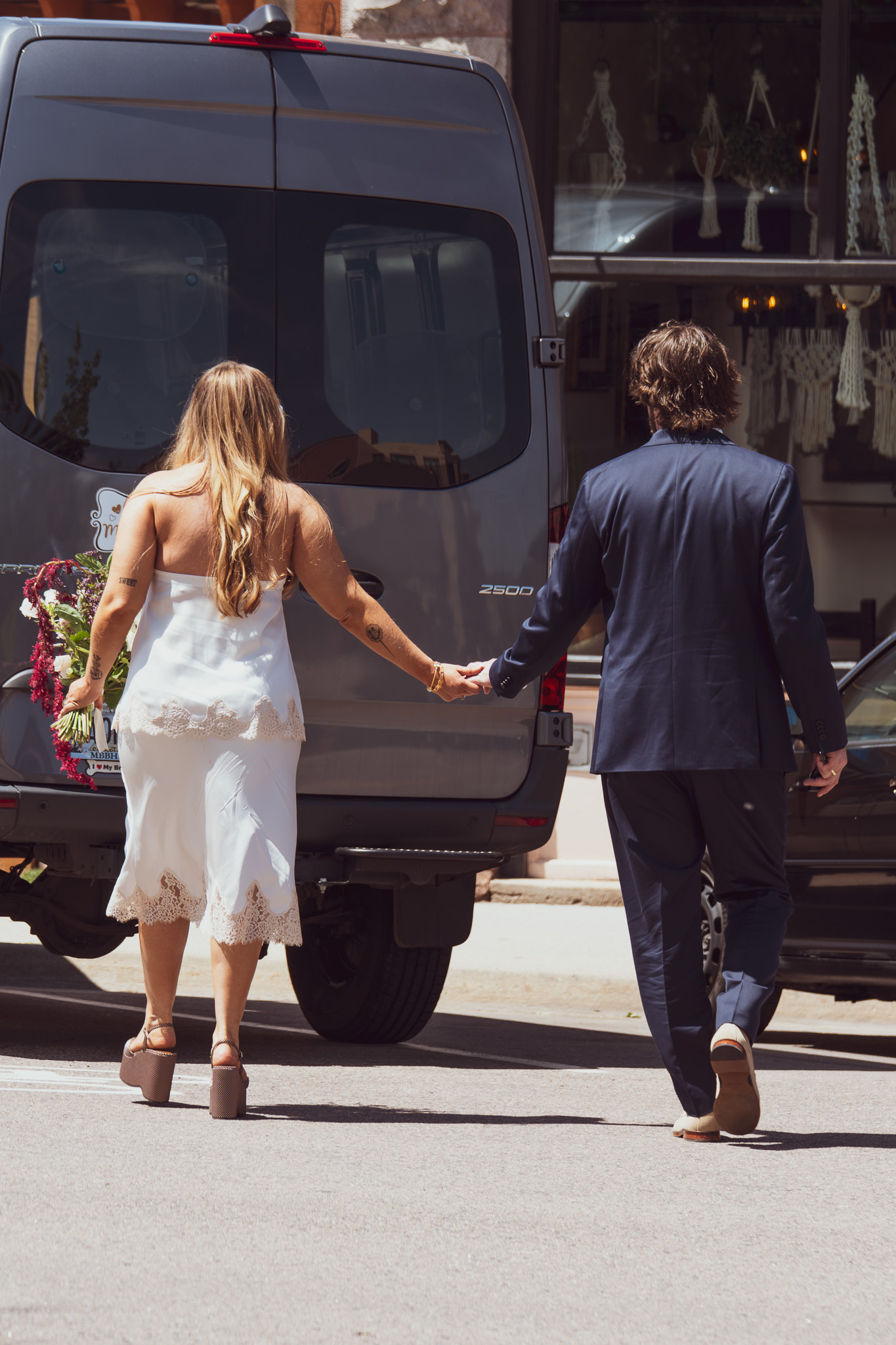 Bride and groom walking hand-in-hand through the streets of Denver after their elopement