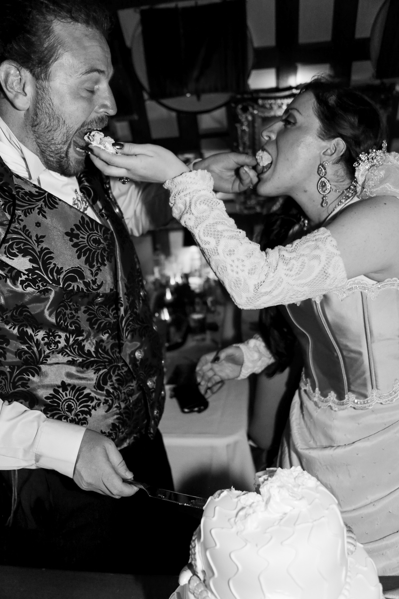 Couple playfully feeding each other wedding cake at their elopement celebration
