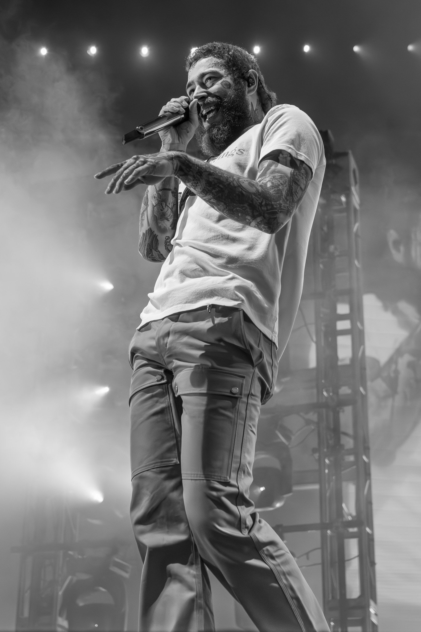 Tattooed performer on stage with microphone — live music photography