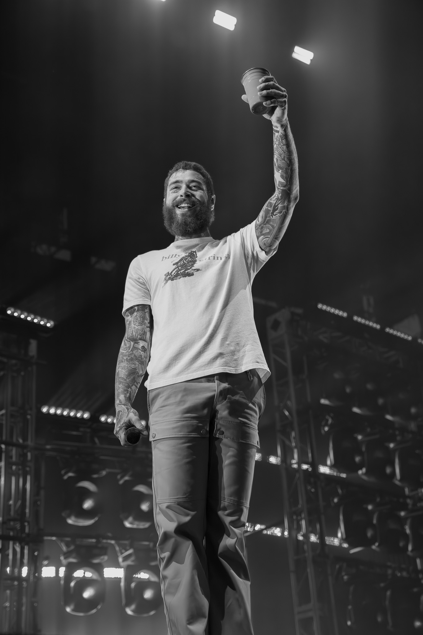 Performer on stage raising a cup — live concert documentation