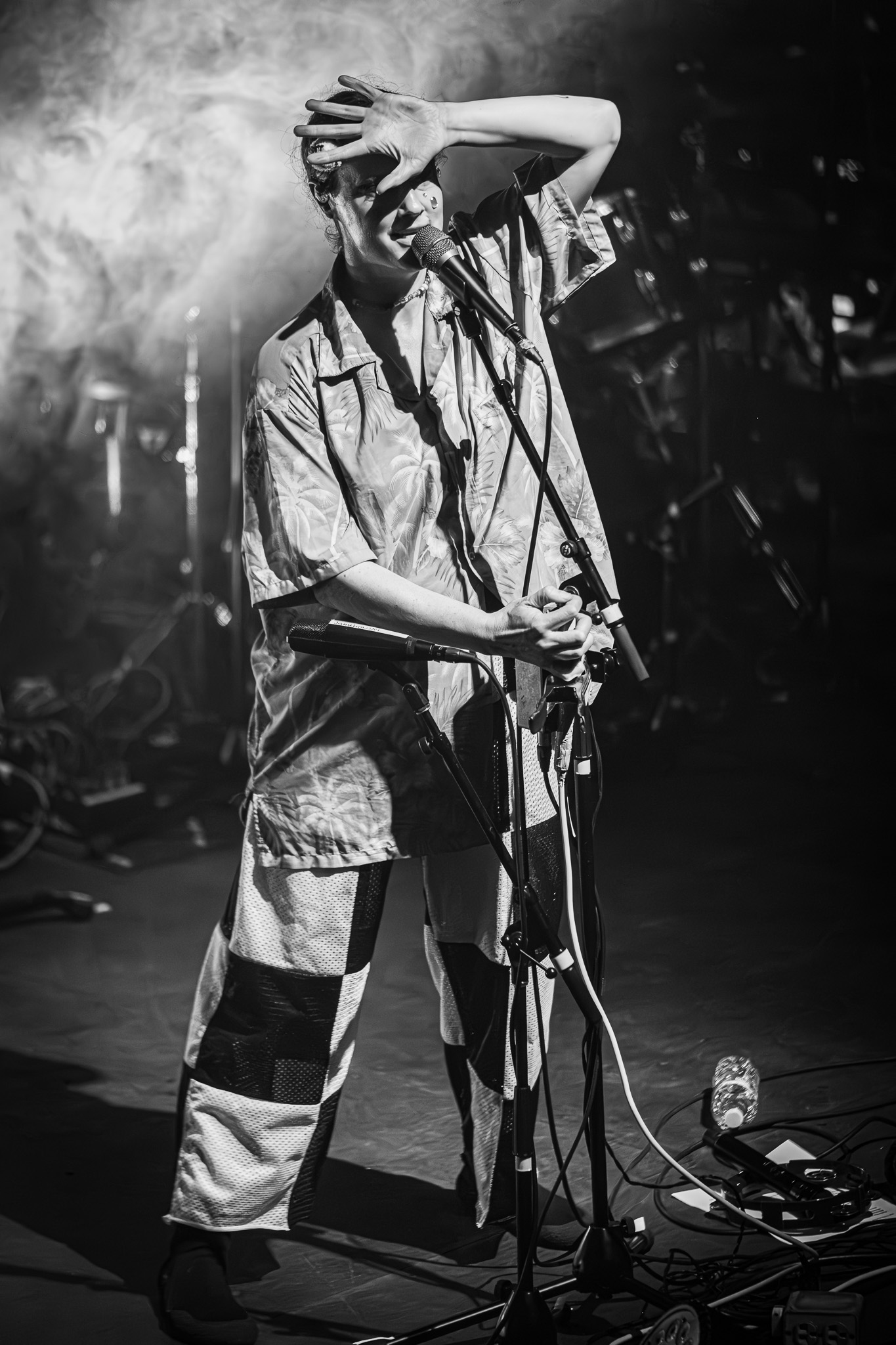 Singer with hand over face at a microphone during an emotional live performance
