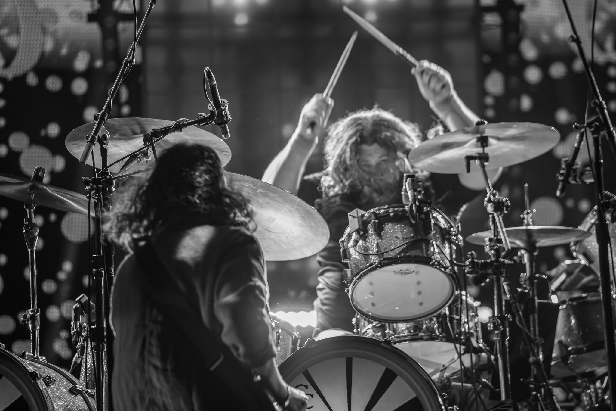 Two musicians from behind with the drummer raising sticks before a set