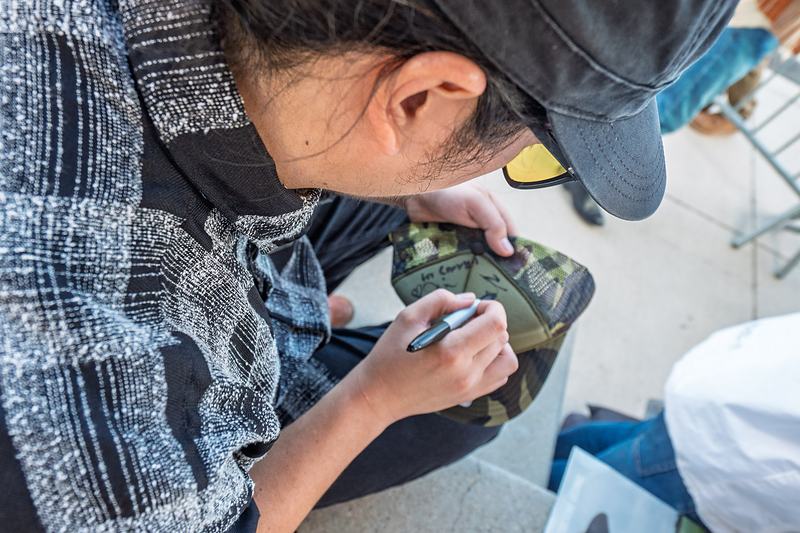 Close overhead view of a band member signing an autograph on merchandise in Winter Park