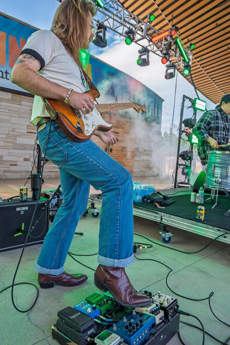 A Rainy Eyes guitarist performs under colored stage lighting during the Winter Park set, live music photography in