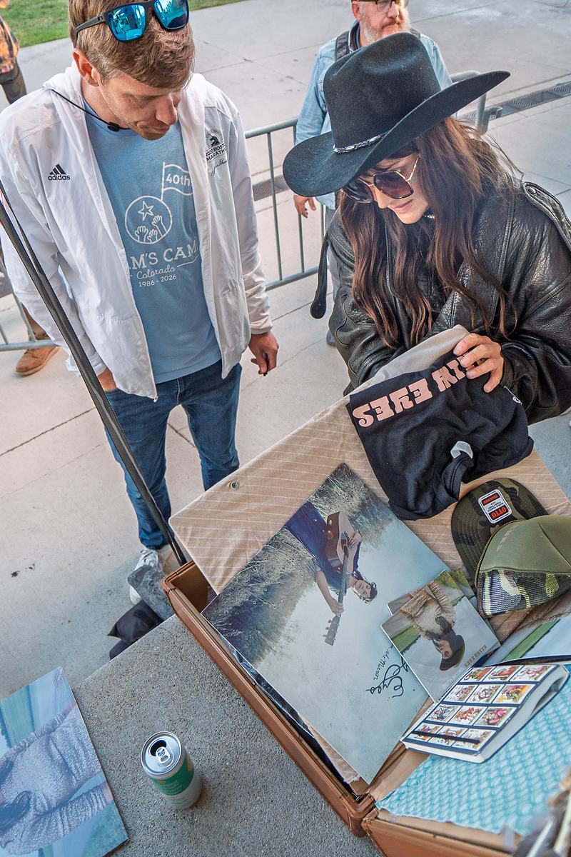 Two band members set out records and merchandise on the table before the show, tour documentary photography