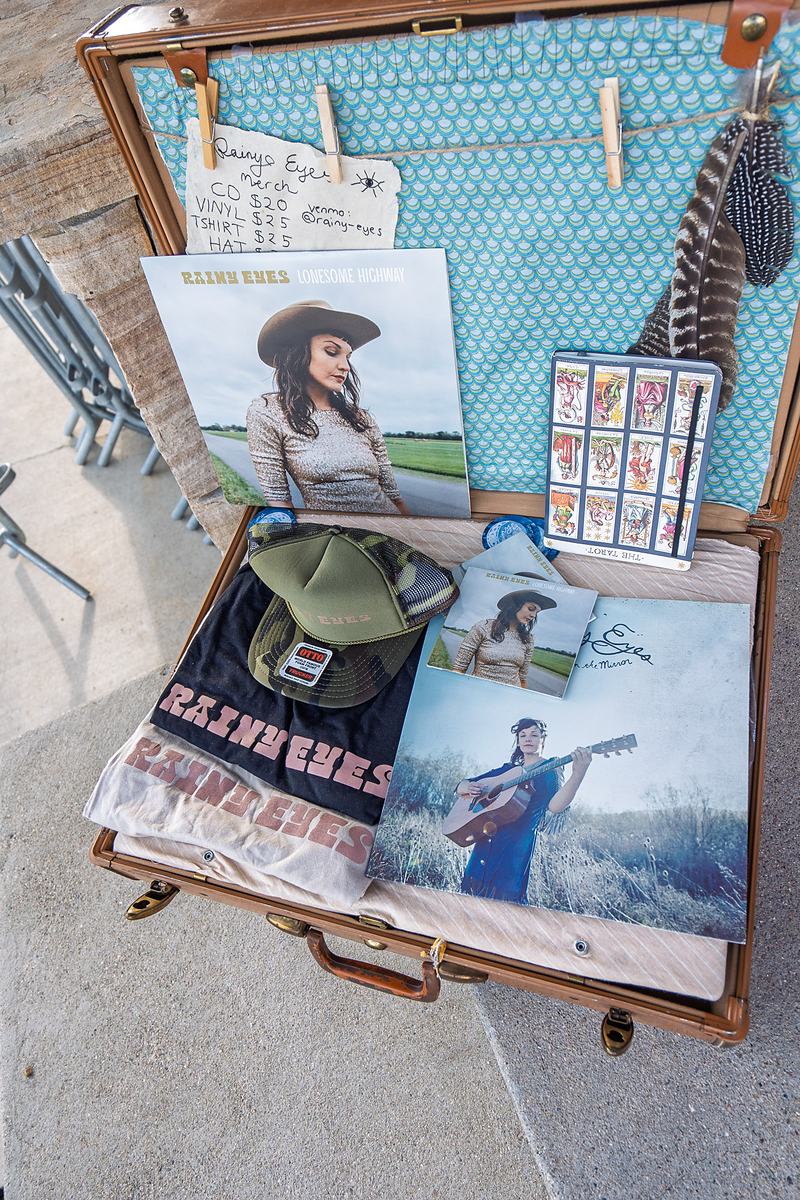 A Rainy Eyes vinyl record displayed on an easel at the merchandise table in Winter Park