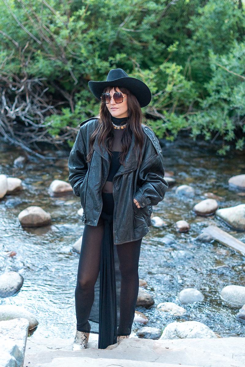 Full-length riverside portrait of the Rainy Eyes vocalist beside a Winter Park creek