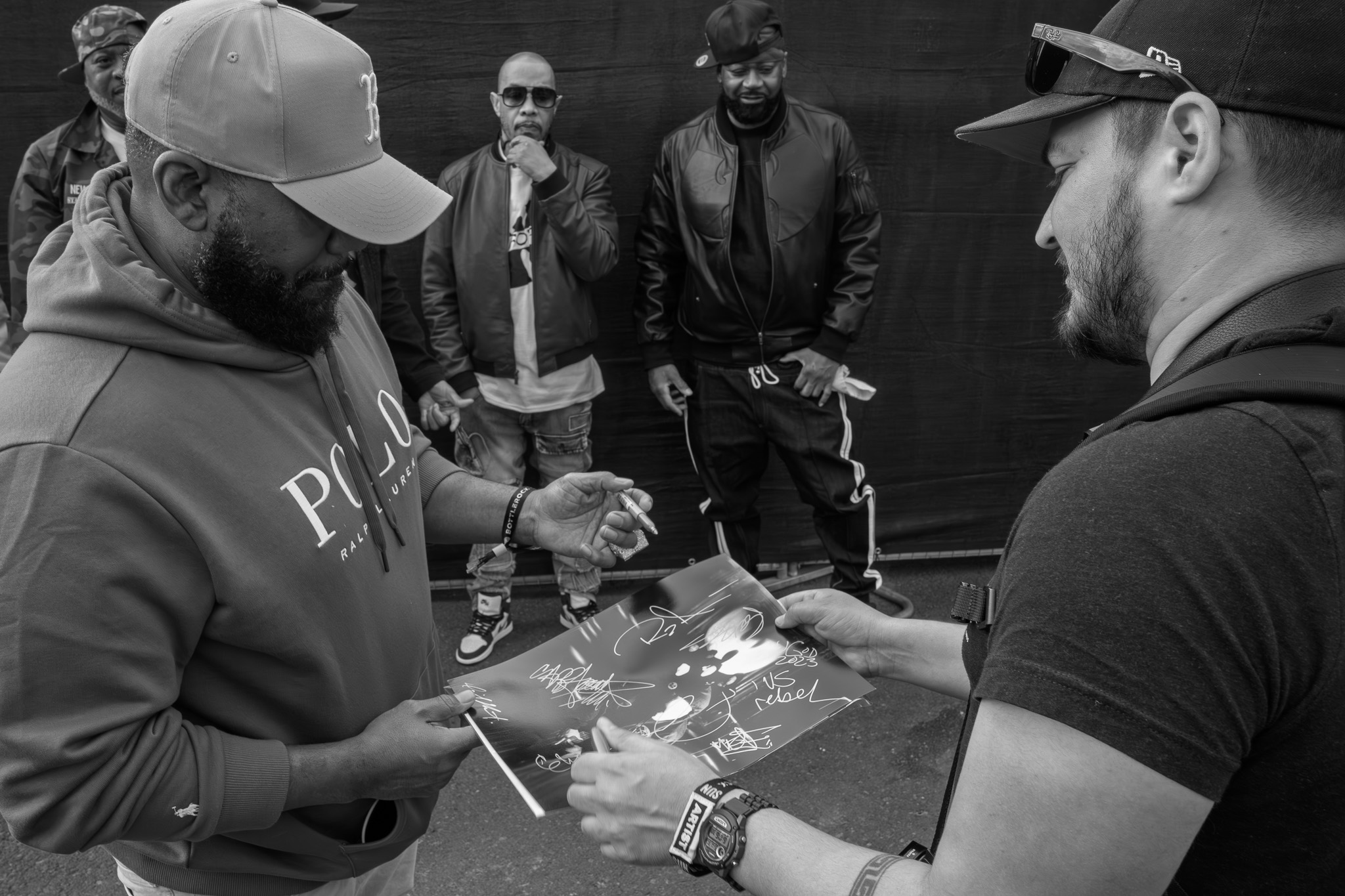 Autograph signing moment — black and white, documentary festival photography