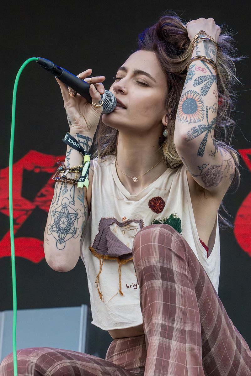 Vocalist with tattooed arms performing live at BottleRock Music Festival