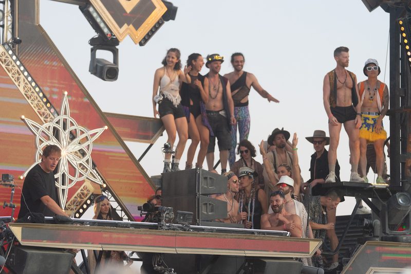 Crowd dancing on top of a decorated art car at Burning Man