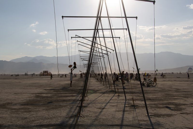 Rows of tall poles and wires stretching across the desert playa at Burning Man
