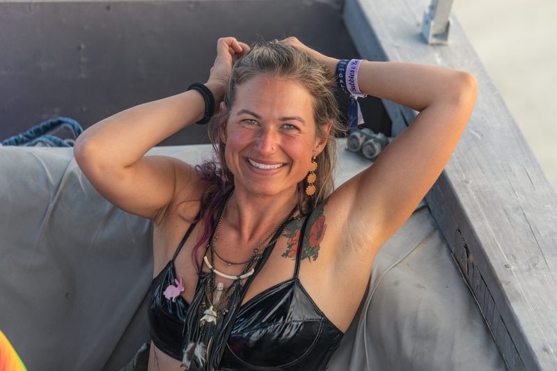 Smiling woman reclining with her hands behind her head at Burning Man
