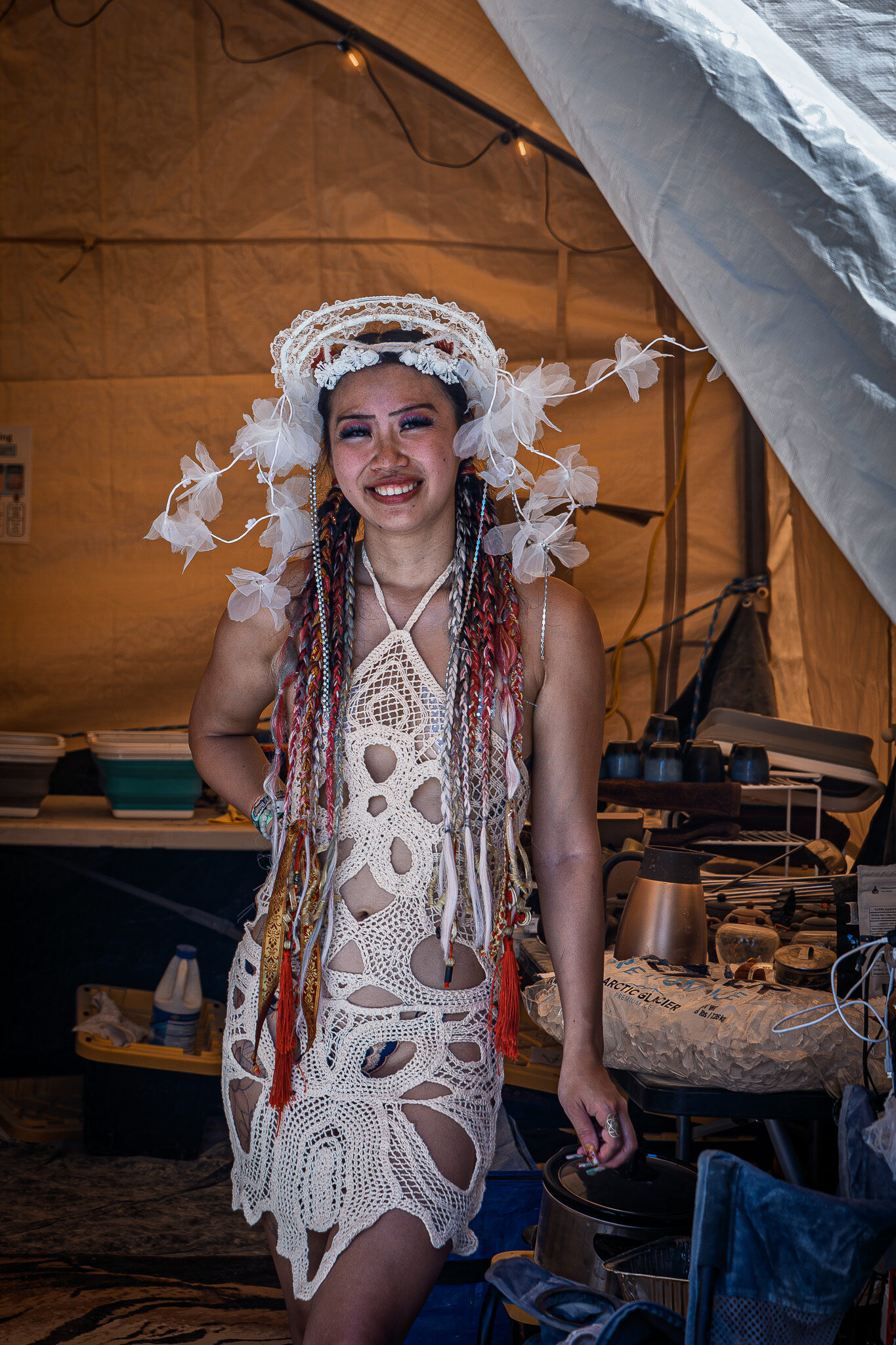A participant in an elaborate feathered costume in a decorated camp at Burning Man