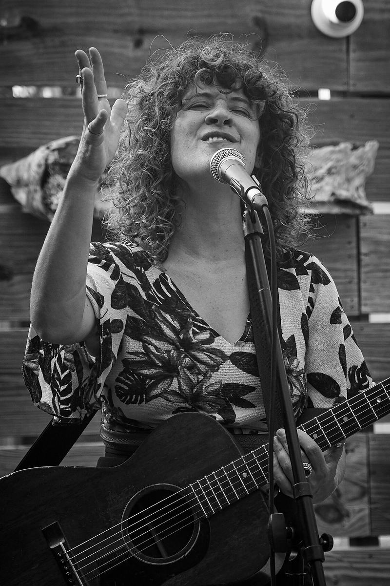 Black and white photograph of a vocalist singing with head back at a live jazz performance