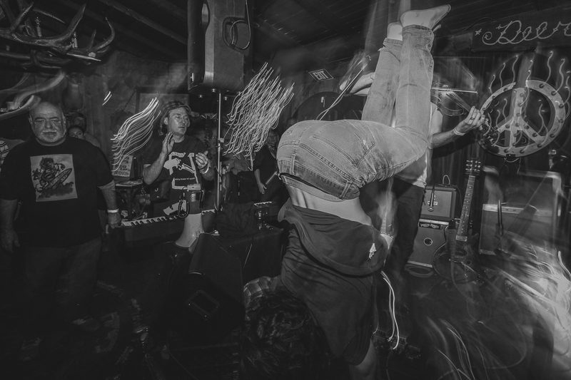 Black and white photo of a performer in a handstand while the crowd watches during an Insects vs. Robots show