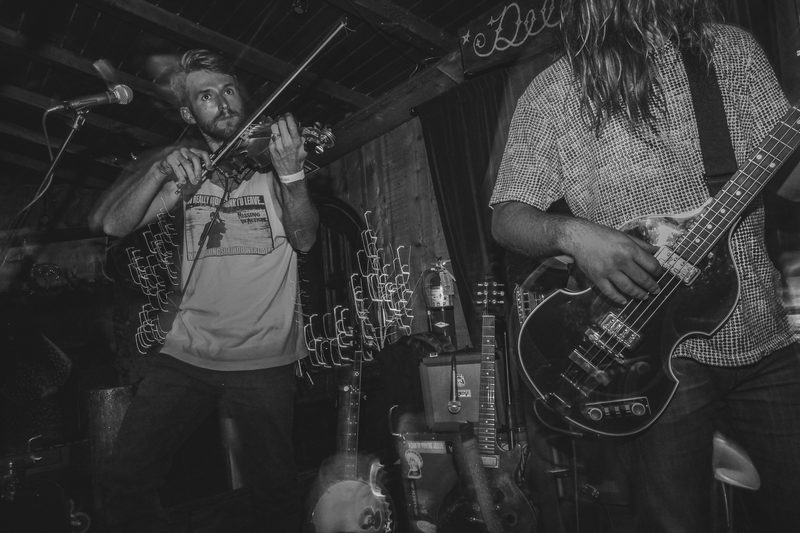 Black and white photo of two musicians performing on a dimly lit stage during an Insects vs. Robots show