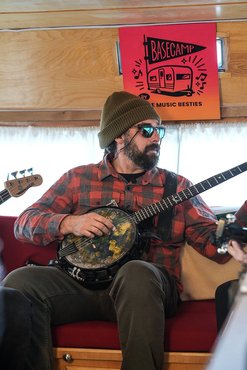 Seated musician playing acoustic guitar at the RendezVan 2026 festival in Bend