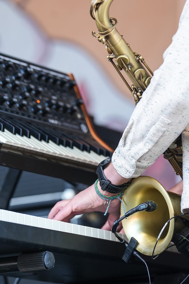 Close view of hands playing a saxophone above a keyboard at the RendezVan 2026 festival