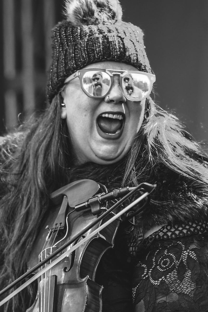 Musician singing and playing with fingerless gloves at RendezVan 2026, expressive live music photography by Tara Lenehan