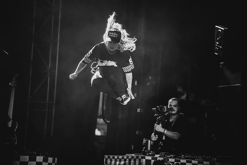 Guitarist jumping from stage riser — action shot, live music documentary photography
