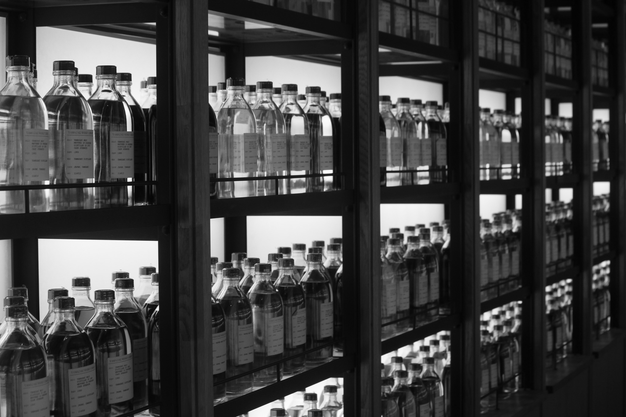 Backlit shelves of glass bottles inside a specialty venue in Japan
